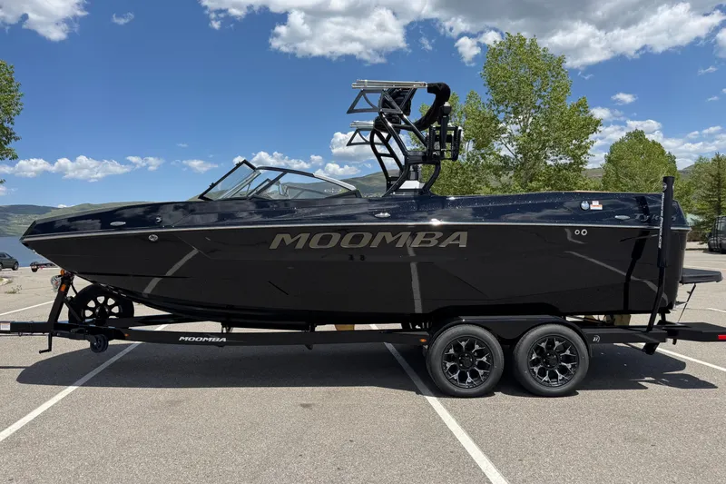 Slide: The Image of 2025 Moomba Tykon boat on trailer, parked outdoors under a clear blue sky. - 6