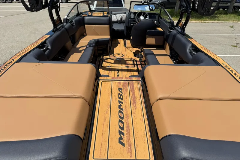 Slide: The Image of 2025 Moomba Tykon boat interior with tan and black seating, showcasing spacious design. - 7