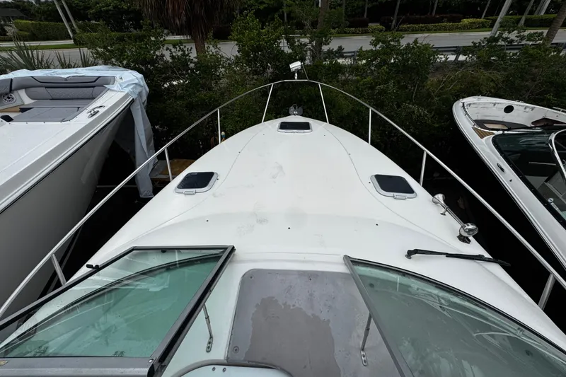 Slide: The Image of 2007 Rinker 300 Fiesta Vee boat docked, view from the bow, surrounded by greenery. - 18
