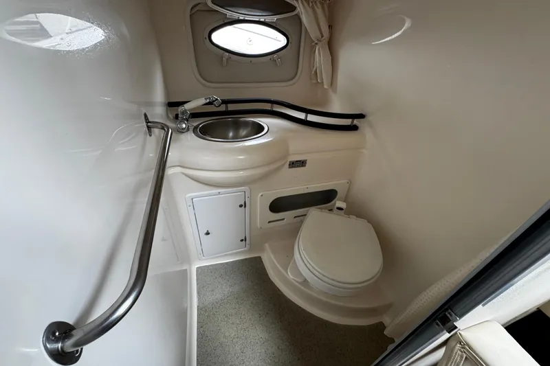 Slide: The Image of 2007 Rinker 300 Fiesta Vee boat bathroom with sink, toilet, and porthole window. - 22