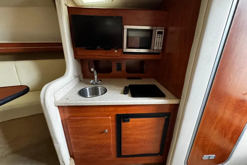 Slide: The Image of 2007 Rinker 300 Fiesta Vee cabin with kitchenette, TV, and microwave. - 23