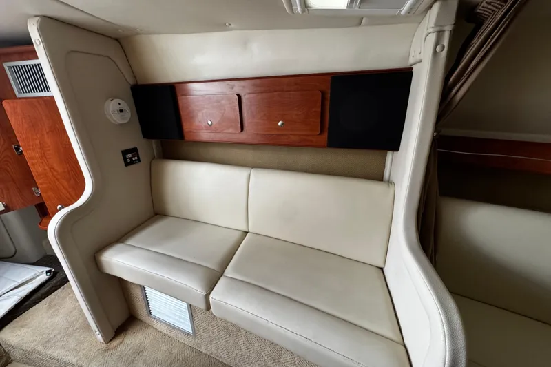 Slide: The Image of 2007 Rinker 300 Fiesta Vee interior with cream seating and wooden cabinetry. - 26