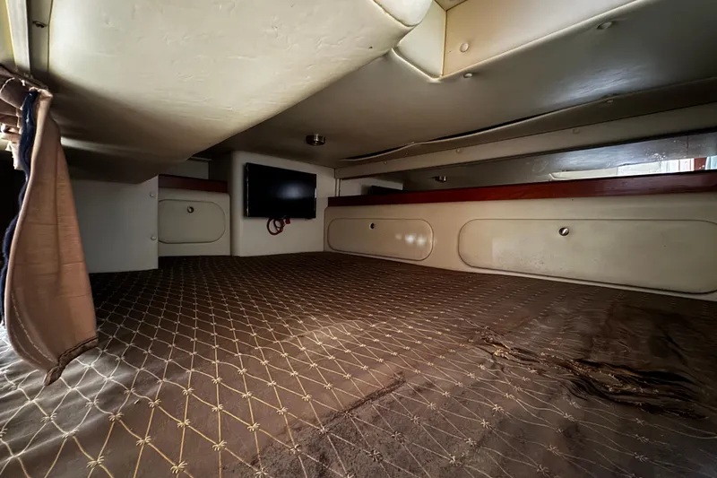 Slide: The Image of 2007 Rinker 300 Fiesta Vee cabin interior with bed, TV, and storage compartments. - 30