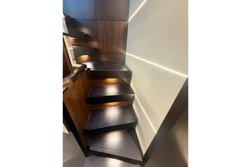 Slide: The Image of Staircase in 2026 Astondoa 66 Fly yacht, featuring modern wood design and ambient lighting. - 22