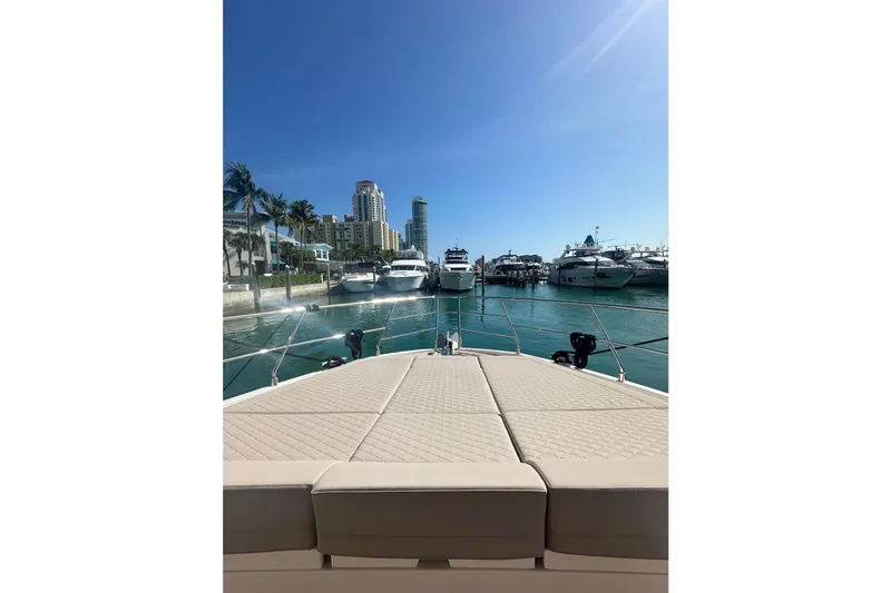 Slide: The Image of Luxurious 2026 Astondoa 66 Fly yacht docked in a sunny marina with city skyline. - 7