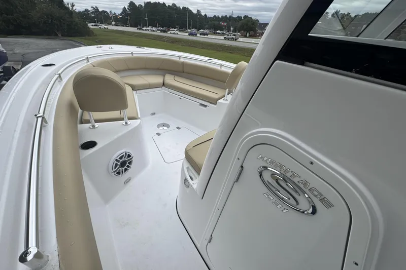 Slide: The Image of 2026 Sportsman Heritage 231 Center Console boat interior with beige seating and speaker. - 17
