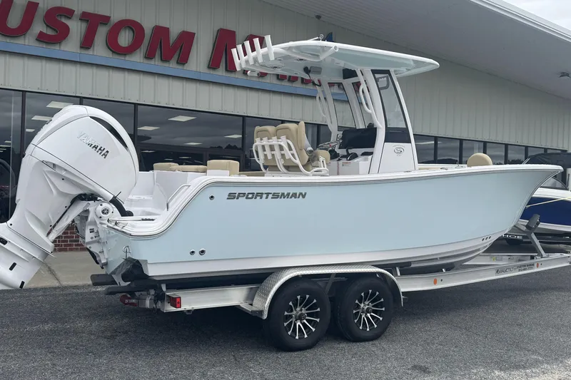 Slide: The Image of 2026 Sportsman Heritage 231 Center Console boat on trailer, parked outside dealership. - 2