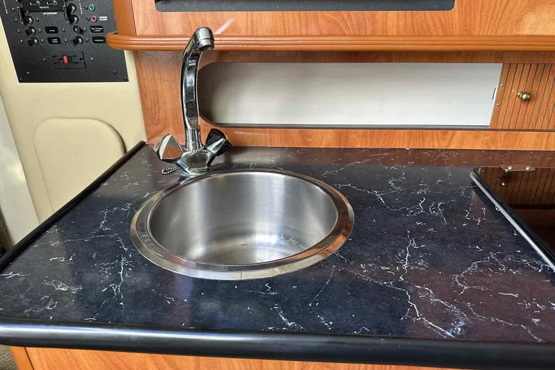 Slide: The Image of 2003 Rinker Fiesta Vee 290 boat interior with sink and countertop. - 13