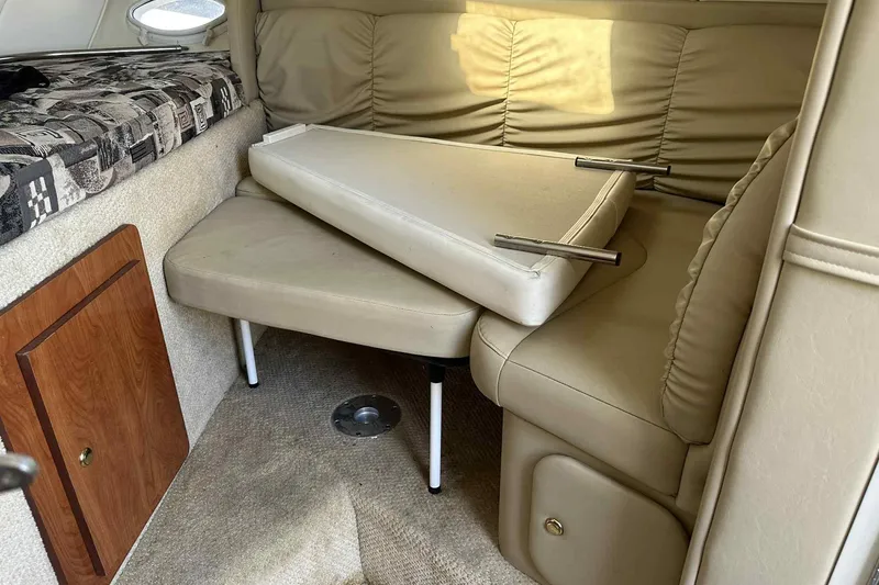 Slide: The Image of 2003 Rinker Fiesta Vee 290 cabin interior with beige seating and storage. - 15