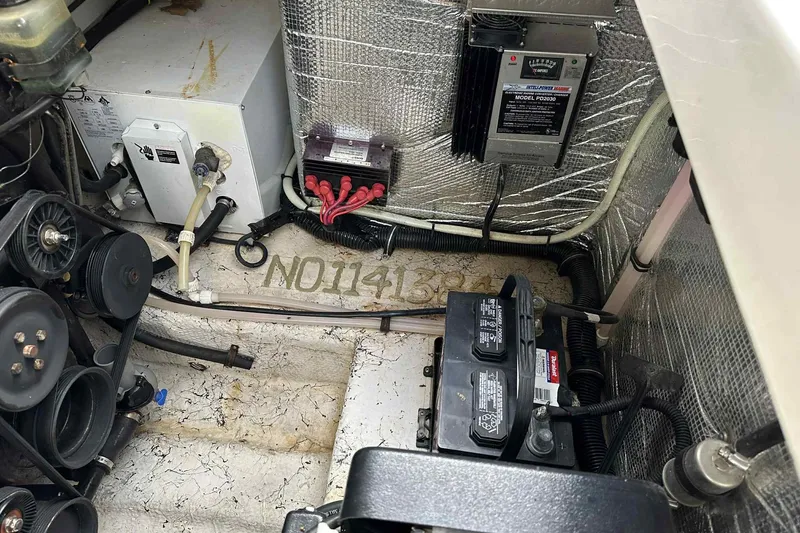 Slide: The Image of Engine compartment of a 2003 Rinker Fiesta Vee 290 boat, showing mechanical components and wiring. - 16