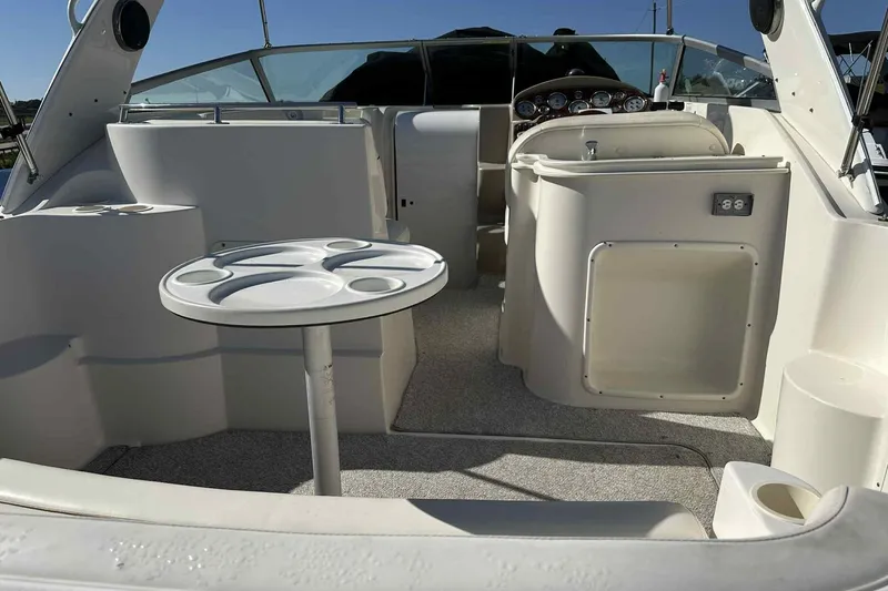 Slide: The Image of 2003 Rinker Fiesta Vee 290 boat interior with seating and table setup. - 2