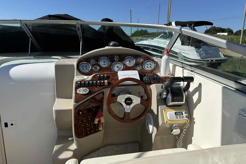 Slide: The Image of 2003 Rinker Fiesta Vee 290 boat dashboard with steering wheel and control panel. - 23