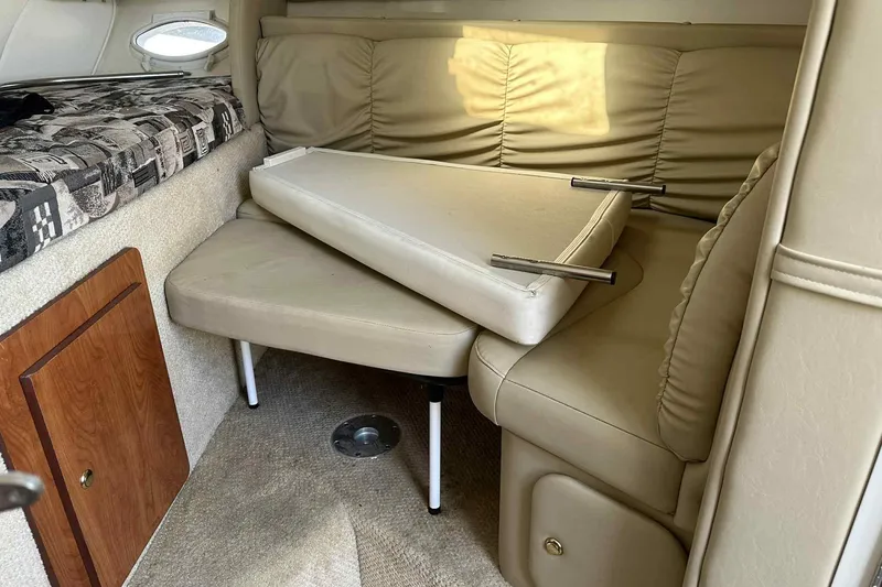 Slide: The Image of 2003 Rinker Fiesta Vee 290 cabin interior with beige seating and compact design. - 28