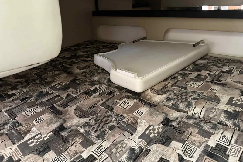 Slide: The Image of 2003 Rinker Fiesta Vee 290 cabin interior with patterned upholstery and foldable table. - 30