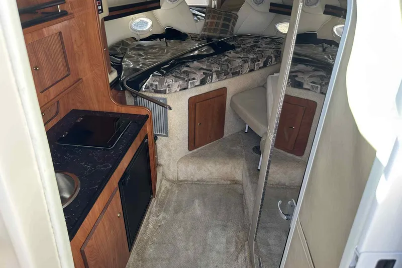 Slide: The Image of 2003 Rinker Fiesta Vee 290 cabin interior with kitchenette and sleeping area. - 34