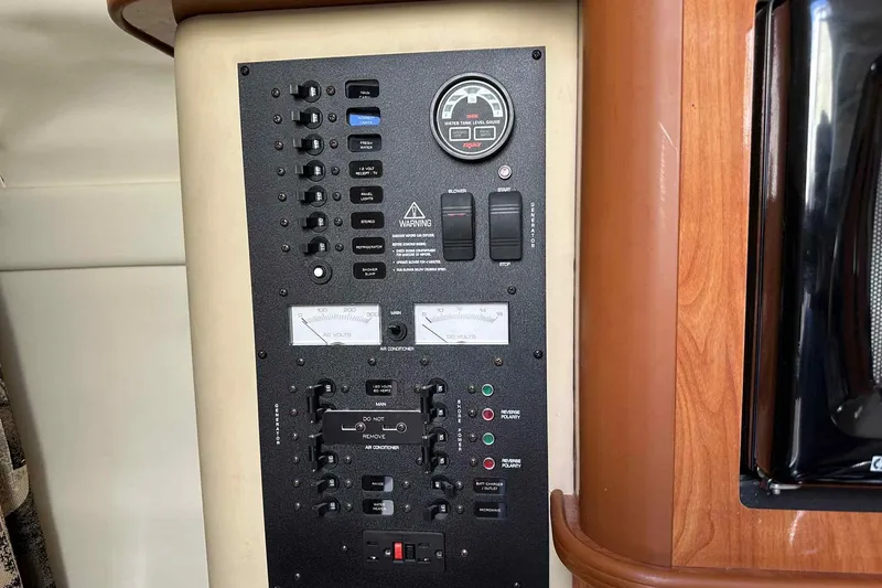Slide: The Image of Control panel of a 2003 Rinker Fiesta Vee 290 boat, featuring various switches and gauges. - 4