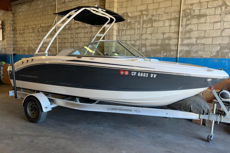 Slide: The Image of 2017 Chaparral 19 H2O Sport boat on trailer in a garage setting. - 2
