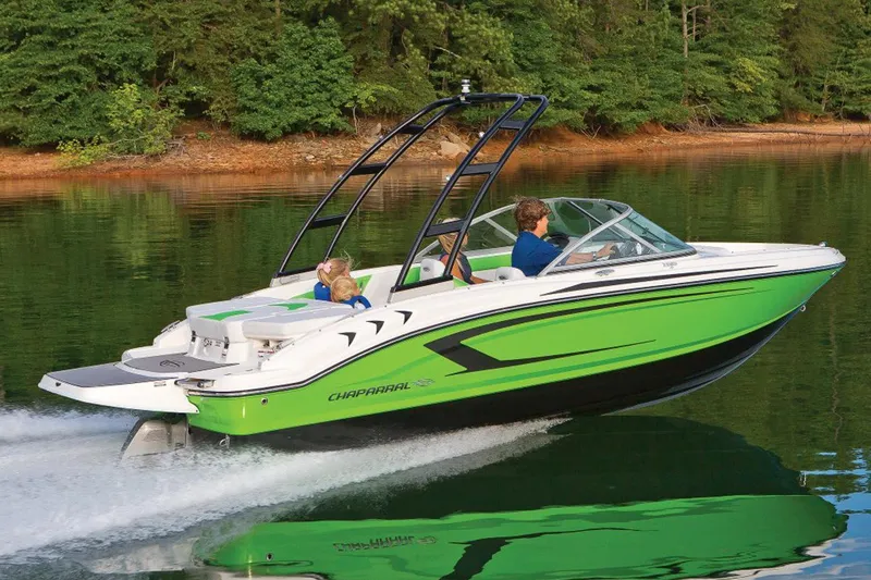 Slide: The Image of Manufacturer Provided Image: 2017 Chaparral 19 H2O Sport boat cruising on a lake with lush green surroundings. - 22