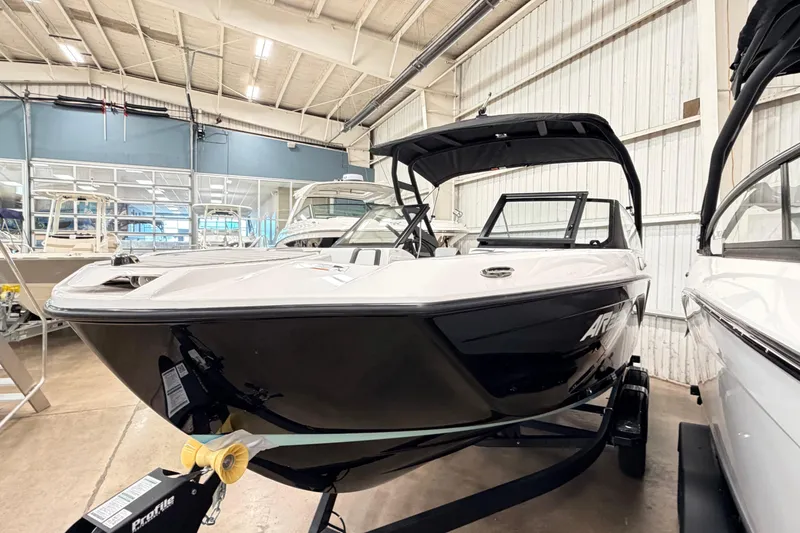 Slide: The Image of 2026 Yamaha Boats AR220 in showroom, sleek design, black and white exterior. - 19