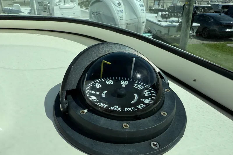 Slide: The Image of Compass on 2017 Pioneer 197 Venture boat dashboard, with boats and cars in the background. - 21