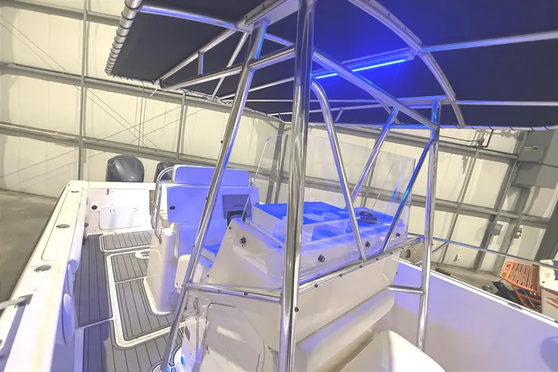 Slide: The Image of 1999 Pursuit 2870 Center Console boat in indoor storage, featuring a T-top and seating. - 10