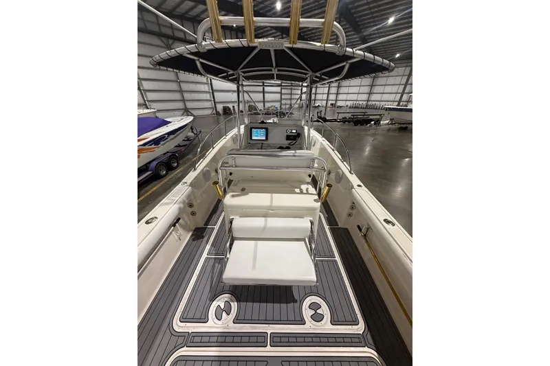 Slide: The Image of 1999 Pursuit 2870 Center Console boat interior with storage compartments and twin engines. - 18