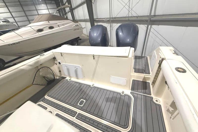 Slide: The Image of 1999 Pursuit 2870 Center Console boat interior with dual engines in a storage facility. - 19