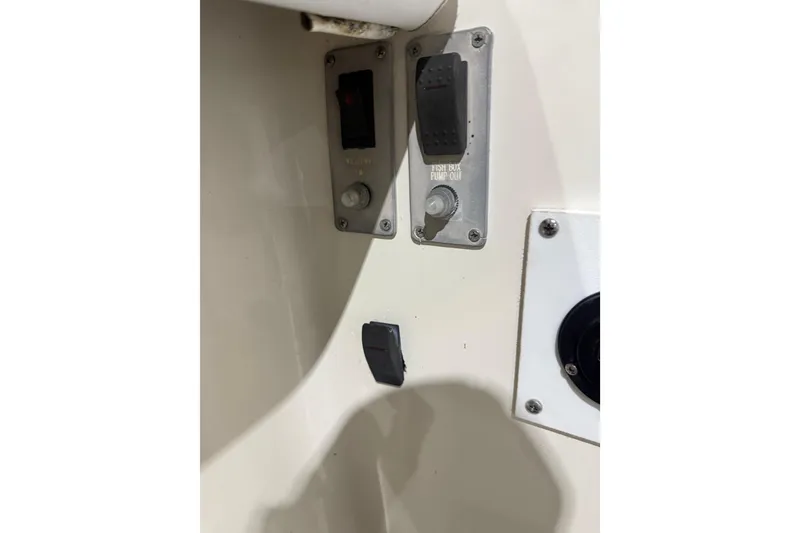 Slide: The Image of 1999 Pursuit 2870 Center Console boat helm with steering wheel and controls in a showroom. - 23