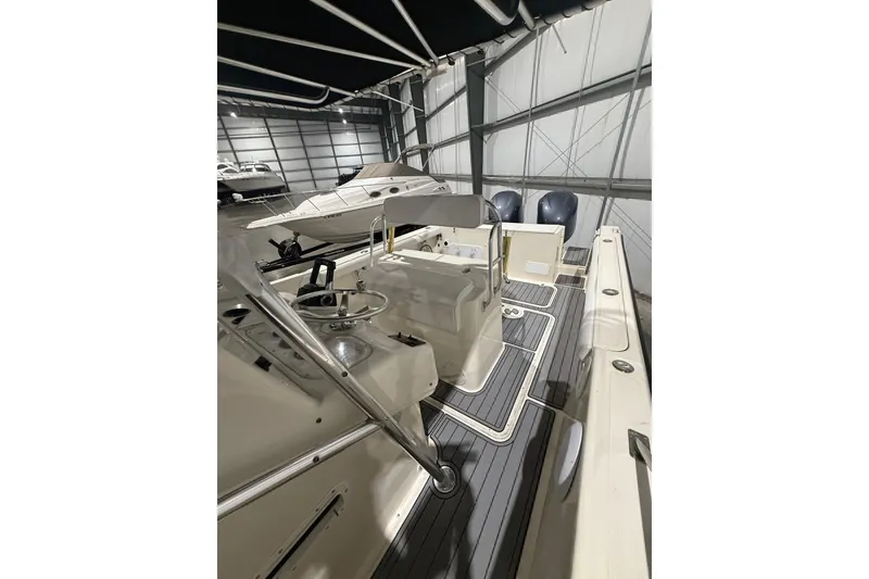 Slide: The Image of 1999 Pursuit 2870 Center Console boat interior with seating and T-top in a storage facility. - 26