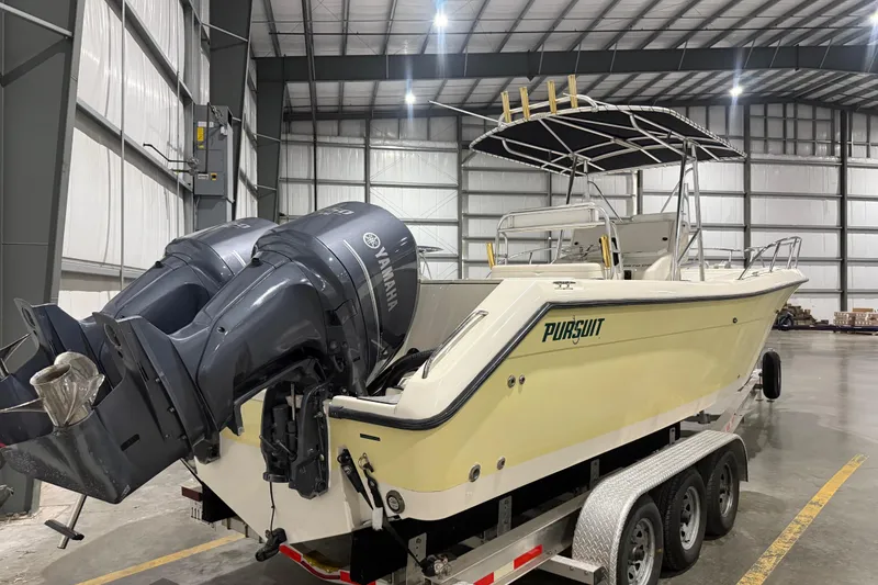 Slide: The Image of 1999 Pursuit 2870 Center Console boat with Yamaha engines in a warehouse. - 3