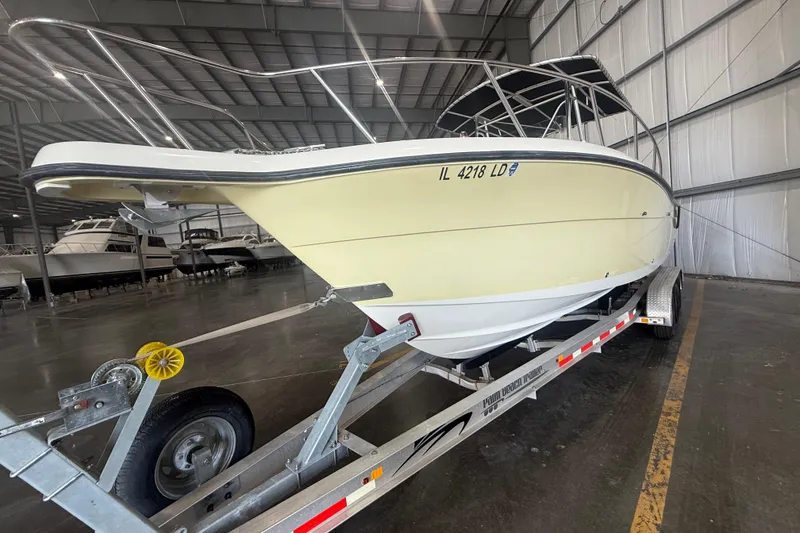 Slide: The Image of 1999 Pursuit 2870 Center Console boat with open hatch and dual engines in a storage facility. - 39