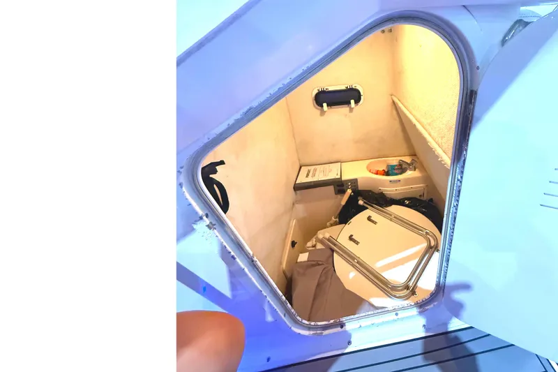 Slide: The Image of 1999 Pursuit 2870 Center Console boat storage compartment with open hatch and visible interior. - 8