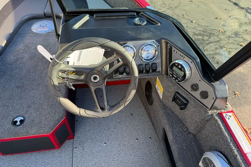 Slide: The Image of 2026 Lund 1775 Adventure Sport boat dashboard with steering wheel and gauges. - 18