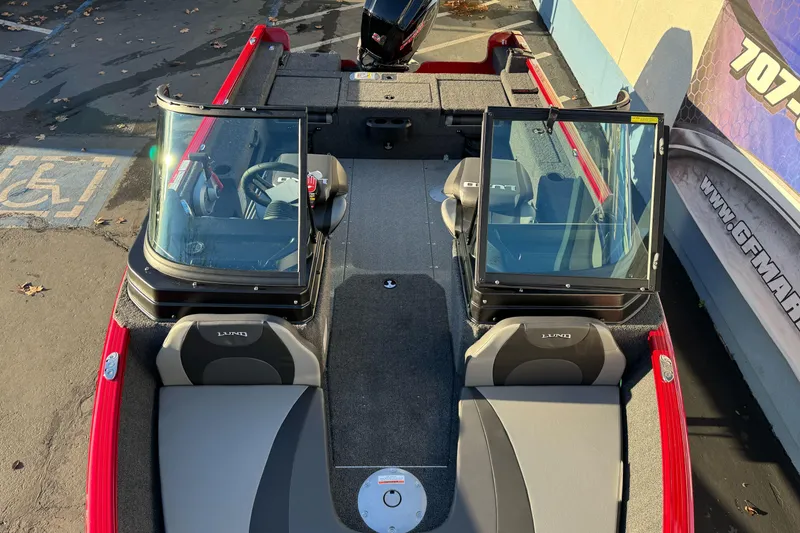 Slide: The Image of 2026 Lund 1775 Adventure Sport boat with dual windshields and seating, parked on pavement. - 8