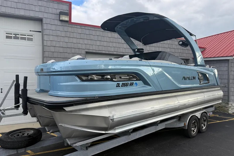 Slide: The Image of 2026 Avalon 2585 Excalibur Tri-toon boat with Mercury 400hp V-10 engine, docked. - 2