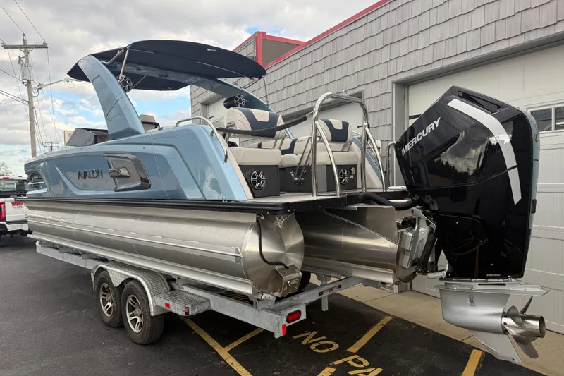 Slide: The Image of 2026 Avalon 2585 Excalibur Tri-toon boat with Mercury 400hp V-10 engine, parked outdoors. - 6