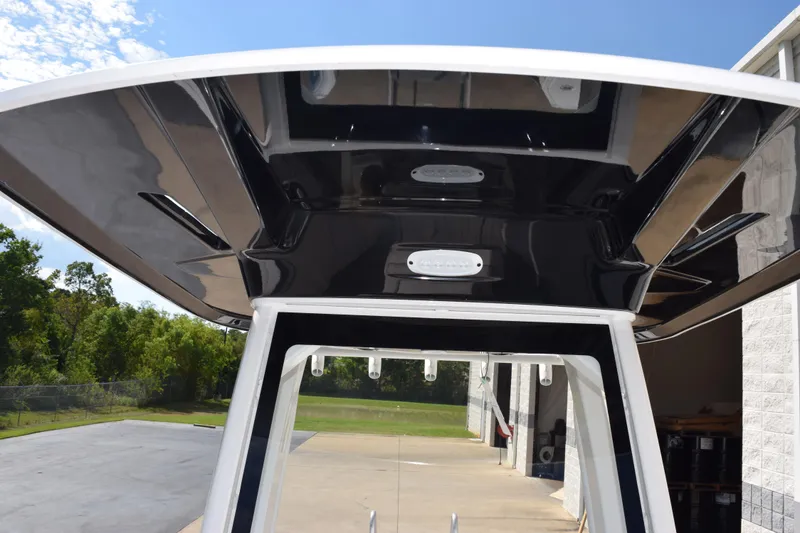 Slide: The Image of 2026 Yamaha Boats 255 FSH Sport H T-top, sleek design, outdoor setting. - 16