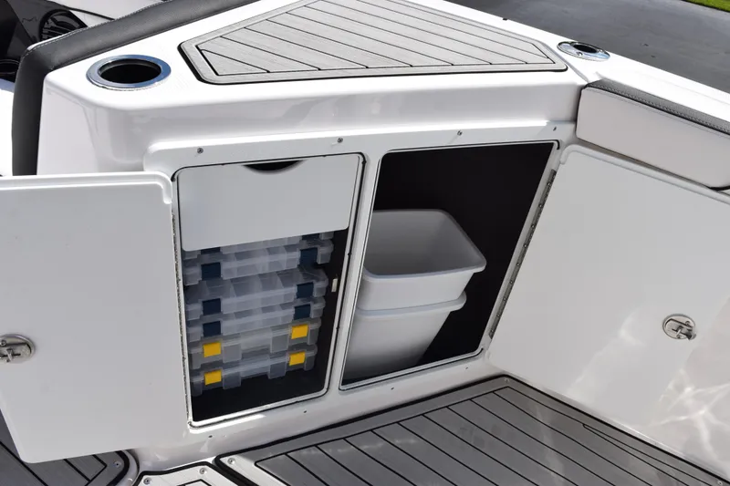 Slide: The Image of 2026 Yamaha Boats 255 FSH Sport H storage compartments with tackle boxes and bin. - 18