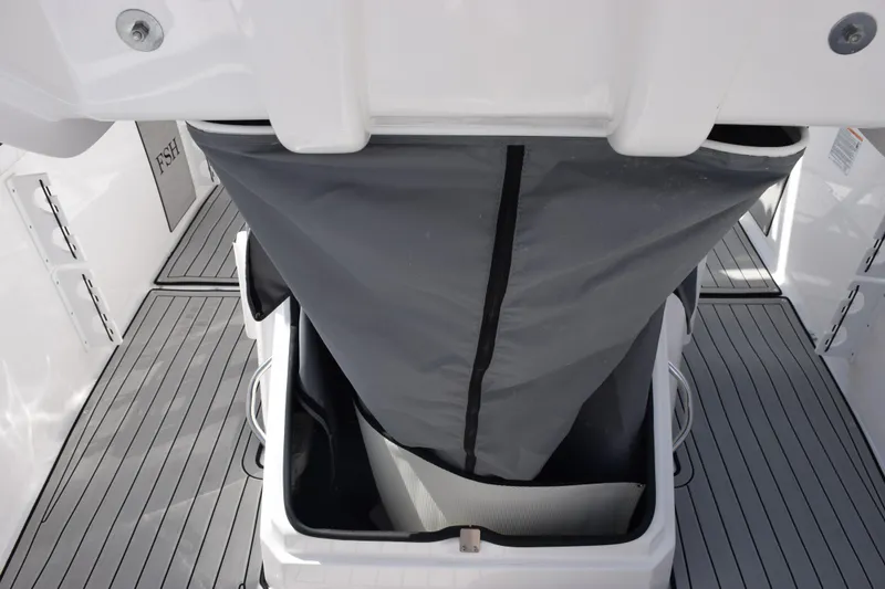 Slide: The Image of 2026 Yamaha Boats 255 FSH Sport H storage compartment with gray cover on deck. - 22