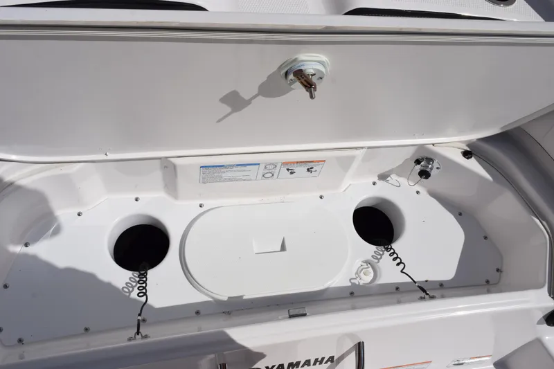 Slide: The Image of Yamaha Boats 2026 255 FSH Sport H storage compartment with open lid and circular openings. - 29