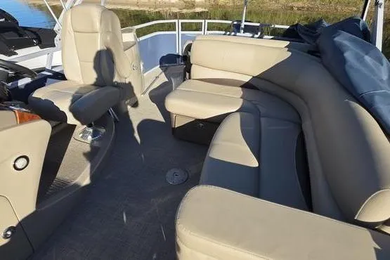 Slide: The Image of 2017 Regency 254 DL3 pontoon boat interior with beige seating and helm chair. - 18