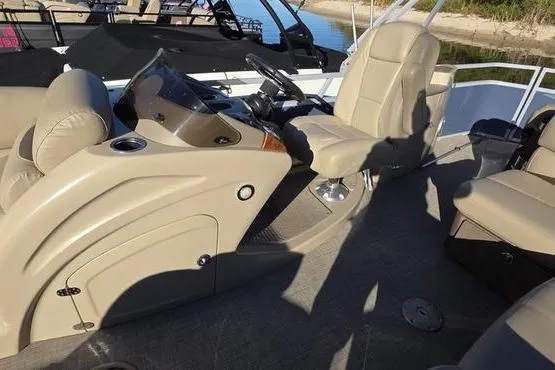 Slide: The Image of 2017 Regency 254 DL3 boat interior with beige seating and steering console. - 19