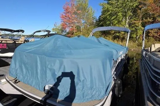 Slide: The Image of 2017 Regency 254 DL3 pontoon boat covered, docked near autumn trees. - 2