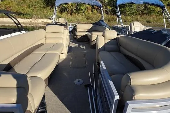 Slide: The Image of 2017 Regency 254 DL3 pontoon boat with beige seating and blue canopies. - 23