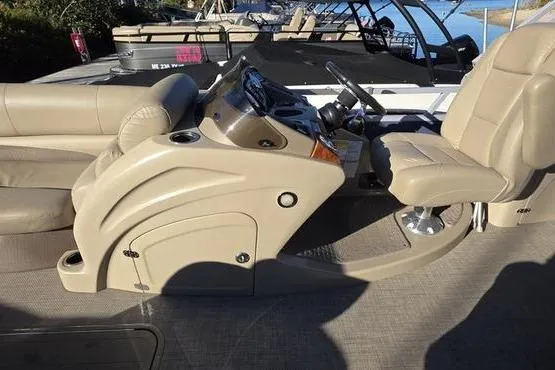 Slide: The Image of 2017 Regency 254 DL3 boat interior with beige seating and steering console. - 27