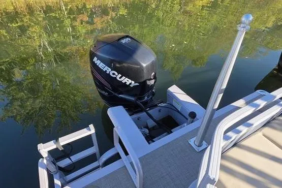 Slide: The Image of 2017 Regency 254 DL3 pontoon boat with Mercury outboard motor on calm water. - 3
