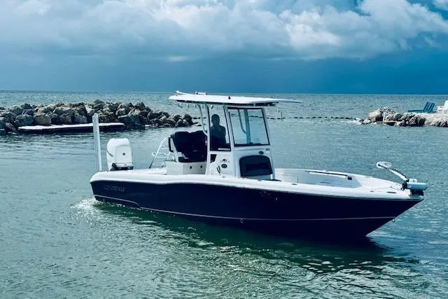 Slide: The Image of 2021 Crevalle 26 HCO boat on calm water with rocky shoreline and cloudy sky. - 11