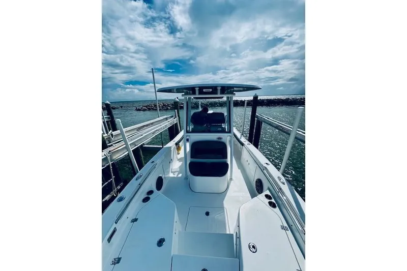 Slide: The Image of 2021 Crevalle 26 HCO boat docked by the sea under a cloudy sky. - 12