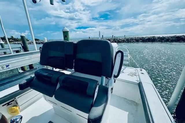 Slide: The Image of 2021 Crevalle 26 HCO boat with dual seats, docked by a scenic waterfront. - 14