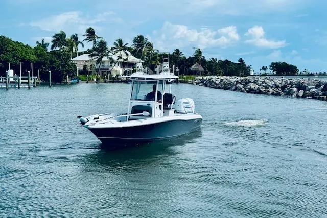 Slide: The Image of 2021 Crevalle 26 HCO boat cruising in a scenic coastal waterway. - 3